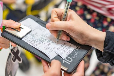 Kredi kartı slipli alışveriş merkezinde müşteri imzası.