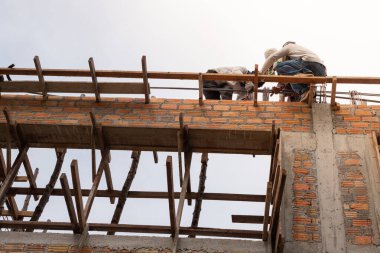 A team of workers working on the upper floor for under construct