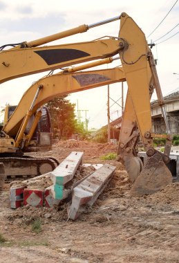 Beton yığınları olan bir kepçe mola veriyor. Güneş ışığıyla