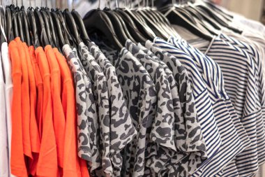 A new collection of woman cloths hanging on a hangers in shopping mall