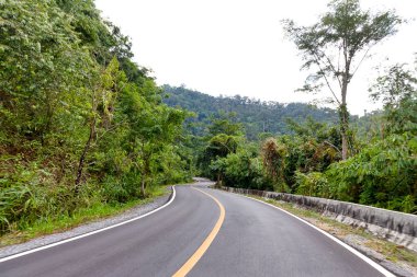 Asphalt winding curve road pass through mountain and forest