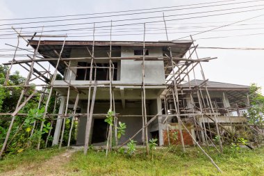 Single two-storey house under construction with wood scaffolding.