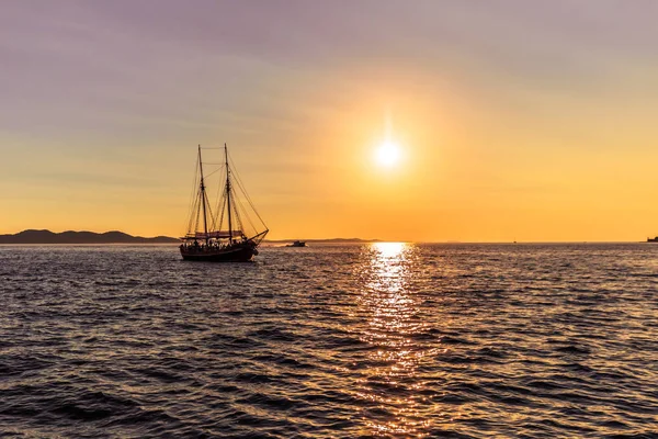 20 de julho de 2016: Um veleiro ao pôr do sol passando pela cidade velha de Zadar — Fotografia de Stock