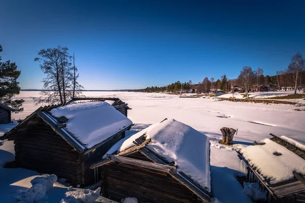 Rattvik - March 30, 2018: Wooden houses by the frozen lake Siljan in Rattvik, Dalarna, Sweden