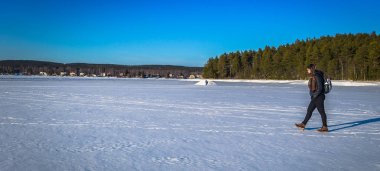 Falun - 31 Mart 2018: Dalarna, İsveç Falun town yakınındaki Framby Udde, donmuş gölde hiking Traveler
