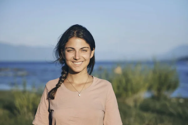 Portrait of a beautiful young woman, without makeup looking at the camera and smiling happily.