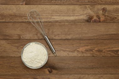 Ahşap zemin üzerinde un ve çırpıcı, üst görünüm