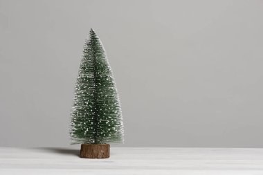 Beyaz ahşap masada küçük noel ağacı, kart konsepti