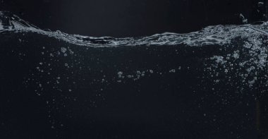 Siyah zemin üzerinde hareket eden su, dalgalar ve kabarcıklar