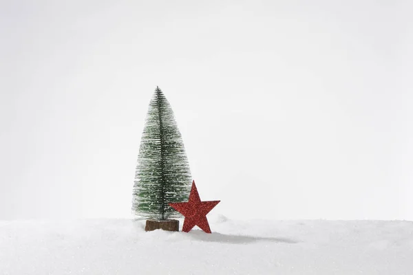 假雪中装饰的人造圣诞树和一颗红星 组成卡片或横幅 — 图库照片