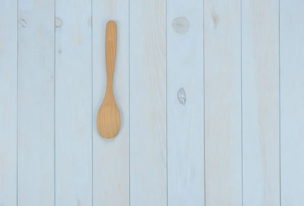 Kitchen items: wooden spoon on blue background