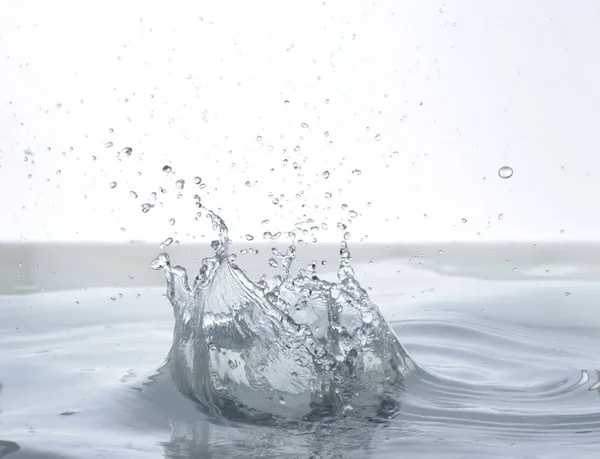 Moving water on white background, jets and drops