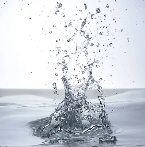 Moving water on white background, jets and drops