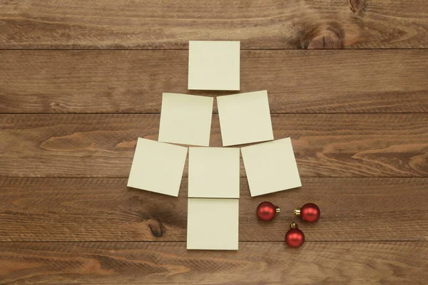 在棕色木制背景上的圣诞树形式的注释或注释 — 图库照片