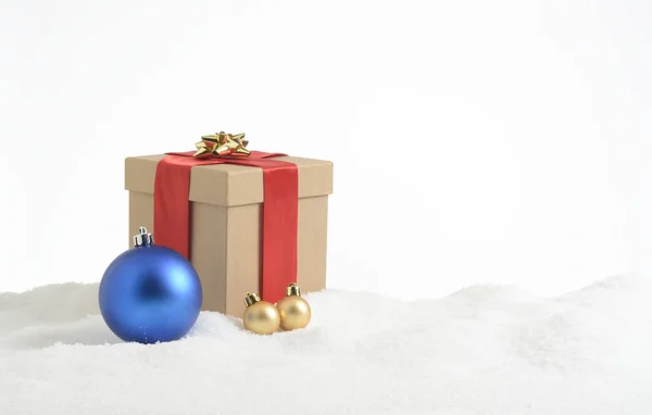 在雪地里的礼品盒和装饰过的蓝色和黄色球 — 图库照片