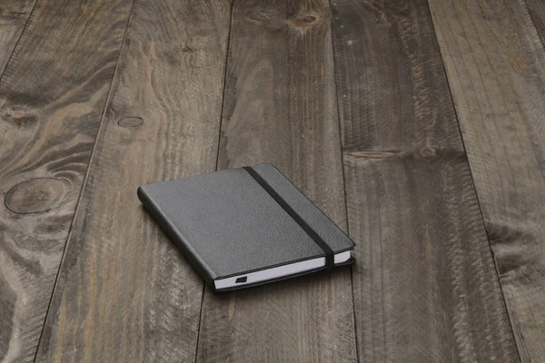 木制底座上的黑色笔记本 — 图库照片