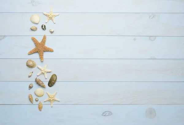 Conchas de mar, estrellas de mar y conchas de mar sobre fondo azul de madera — Foto de Stock