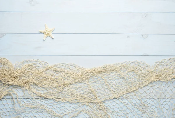 Starfish on blue wooden background with fishing net — Stock Photo, Image