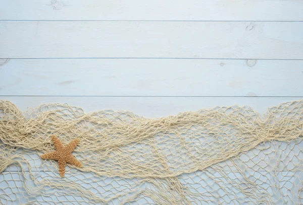 Starfish on blue wooden background with fishing net — Stock Photo, Image