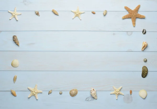 Conchas de mar, estrellas de mar y conchas de mar sobre fondo azul de madera — Foto de Stock