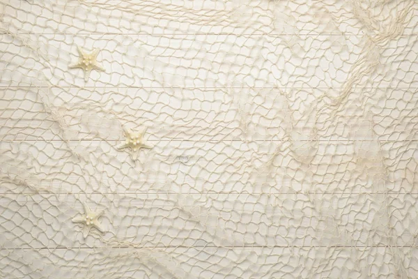 Starfish on white wooden background with fishing net — Stock Photo, Image