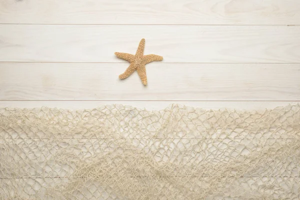 Estrella de mar sobre fondo de madera blanca con red de pesca — Foto de Stock