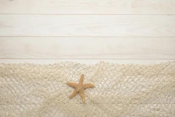 Estrella de mar sobre fondo de madera blanca con red de pesca — Foto de Stock