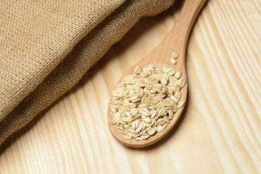 Ahşap arka planda bir kasede çiğ yulaf