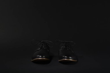 Siyah bir arka plan üzerinde siyah ayakkabı