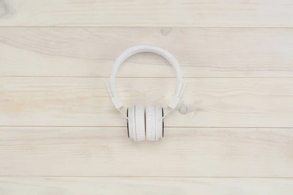 Auriculares sobre fondo de madera blanco — Foto de Stock