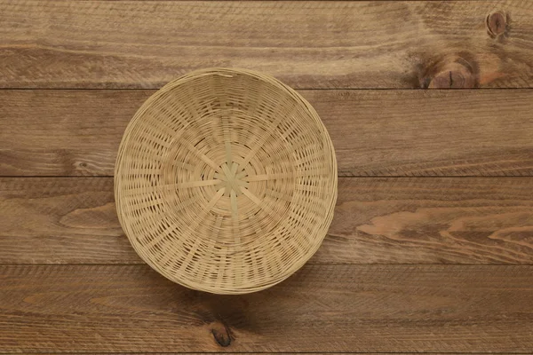 Cesta de vime para comida em fundo de madeira — Fotografia de Stock