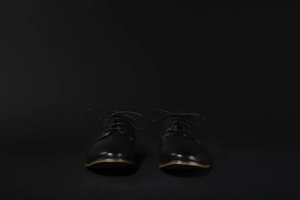 Sapatos pretos em um fundo preto — Fotografia de Stock