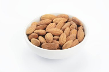 Beyaz arka planda beyaz seramik bir kasede çiğ badem.