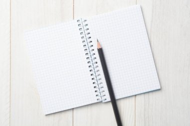 Beyaz tahta zemin üzerinde boş bir defter ve kalem, konsept yaz