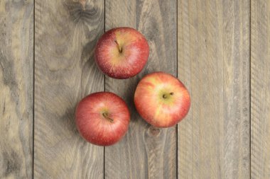 Ahşap zemin üzerinde kırmızı elmalar, yukarıdan görünüm