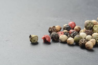 Siyah taş üzerine beş çeşit biber, makro.