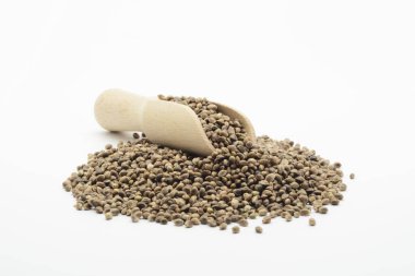 Beyaz arka planda tahta kaşıkta kenevir tohumu