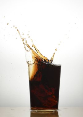 Beyaz arkaplanda kola bardağına su sıçrat