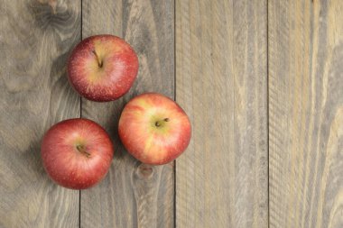 Ahşap zemin üzerinde kırmızı elmalar, yukarıdan görünüm