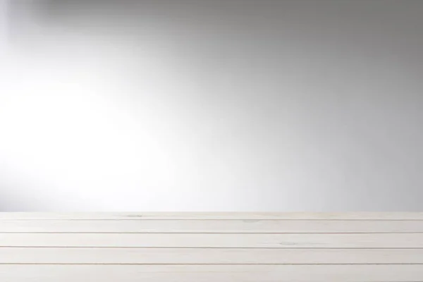 Boş beyaz ahşap masa arkaplanı, duvarda ışık efekti