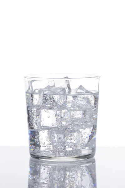 白底上有气泡和冰块的清爽饮料的杯子 — 图库照片