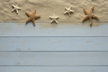 Mavi ahşap arka planda kumlu denizyıldızı, üst manzara