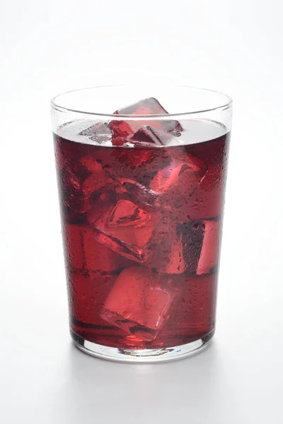 Glass of wine with ice cubes on white background, cold drink