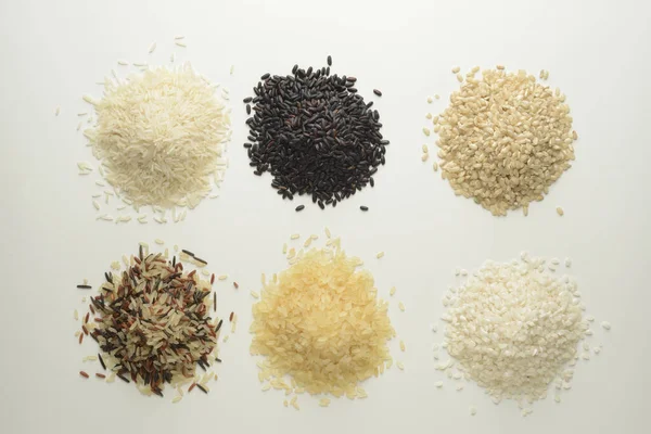 Beyaz Arka Planda Çiğ Pirinç Farklı Çeşitlerde — Stok fotoğraf