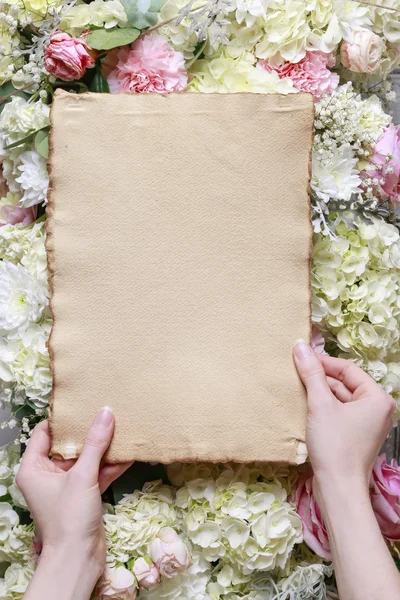 Žena držící vintage prázdný list papíru. Romantická květina nebo — Stock fotografie