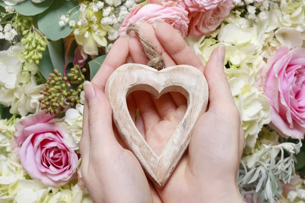 Mujer sosteniendo un corazón de madera. Adorno de flor romántica —  Fotos de Stock