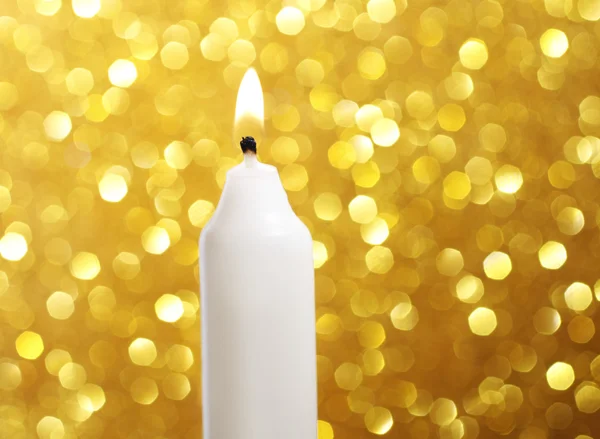 Pojedynczy biały świeca i złota błyszczące światła Bożego Narodzenia — Zdjęcie stockowe