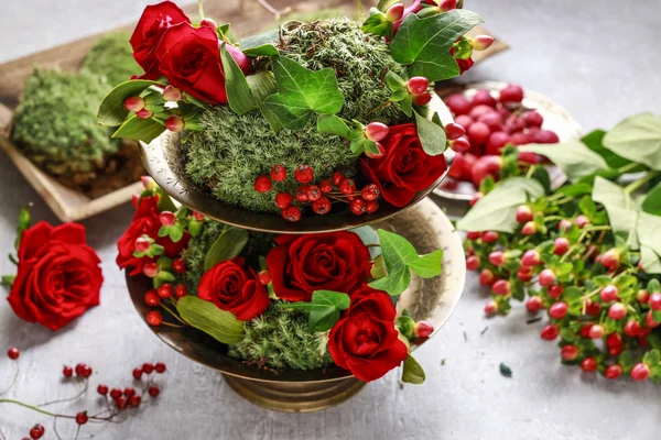 Decoración floral con rosas rojas, muérdago y musgo. Paso a paso —  Fotos de Stock