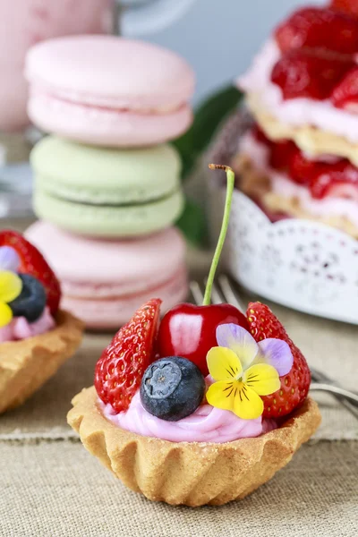 Cupcakes mit frischen Früchten und essbaren Blumen. — Stockfoto