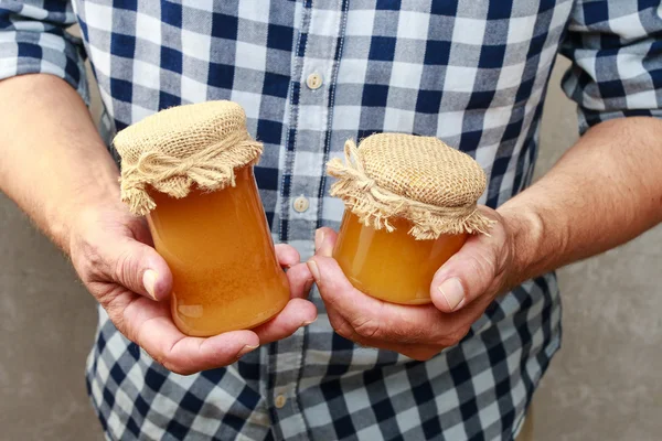 Hombre sosteniendo frascos de miel —  Fotos de Stock